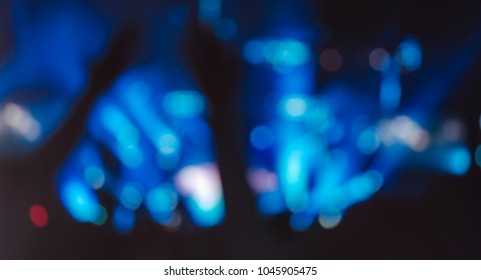 Blurred photo of Christian worship God together in Church hall in front of music stage and light bokeh effected.raised hand and praise the LORD.Music concert background.