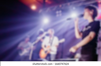 Blurred photo of Christian worship God together in Church hall in front of music stage.raised hand and praise the LORD.Music team concert background.Worshiper and worship team in Church.Concert image.