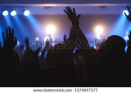 Blurred photo of Christian worship God together in Church ,raised hand and praise the LORD ,concert background.