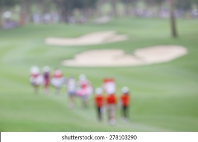 Blurred Photo Of Golfer And Audience On Green In Golf Tournament.