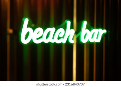 Blurred photo of a neon signboard of a beach bar. - Powered by Shutterstock