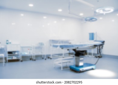 Blurred Photo Of The Operating Room In A Hospital. Surgical Equipment With Operating Table. Medical Device For Emergency Patient In Blue Tone Style. Blank Surgery Room. Clinic Interior For Background.