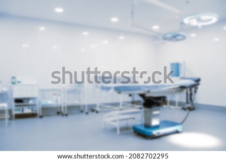 Blurred photo of the operating room in a hospital. Surgical equipment with operating table. Medical device for emergency patient in blue tone style. Blank Surgery Room. Clinic interior for background.