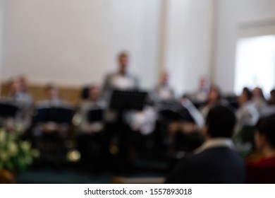 Blurred Photo. The View From The Audience, People Are Listening To A Young Man Singing Solo