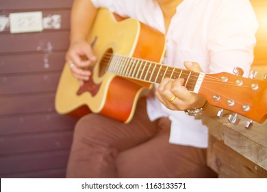 blurred photo,
The young man was happy to play the classic guitar with his lover, and loved the song by playing his favorite guitar on a wooden bench by the porch of his home in the morning. - Powered by Shutterstock