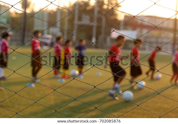Blurred photo of youth training football\
in the football practice field. Sport\
concept.
