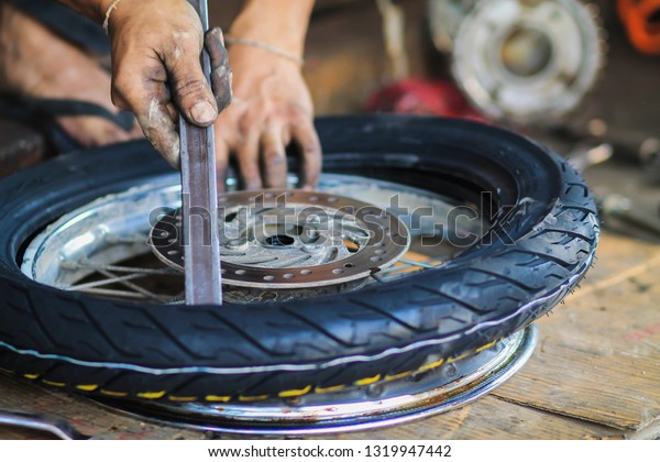 blurred photo,Motorcycle repair after a tire leak\
during a long journey. Modifying some parts of a motorcycle when it\
is used for a certain period of time by an expert\
technician.\
Motorcycle\
repair