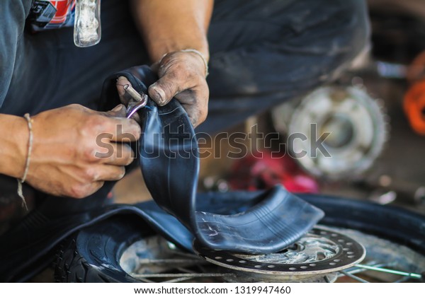 blurred photo,Motorcycle repair after a tire leak\
during a long journey. Modifying some parts of a motorcycle when it\
is used for a certain period of time by an expert\
technician.\
Motorcycle\
repair
