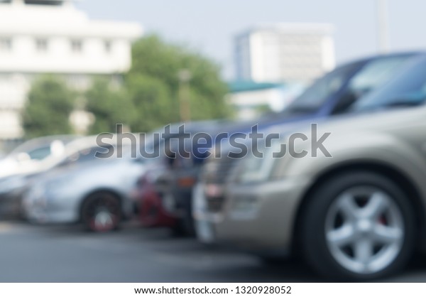 Blurred\
picture of cars parking in open area, blurred cars parking in open\
area of a university with surrounding\
trees