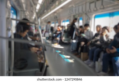 Blurred Picture Of People Sitting In Korea Train. Busy Moment Of Persons Reading News Paper And Using Smart Phones. Transport Concept And Technology Addicted.