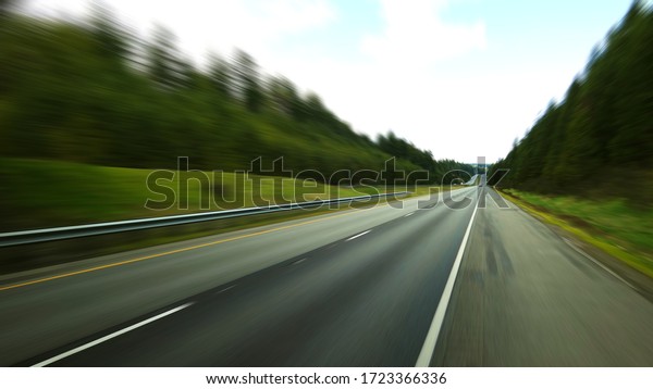 blurred picture of tress and\
highway