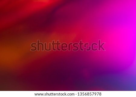 Blurred pink and red abstract lens flare background. Defocused glow effect. Illuminated bokeh