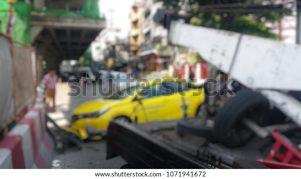 Blurred a police\
department tow truck are towing yellow vehicle are accident on the\
road to prevent the danger of accidental duplications and delivers\
to the garage