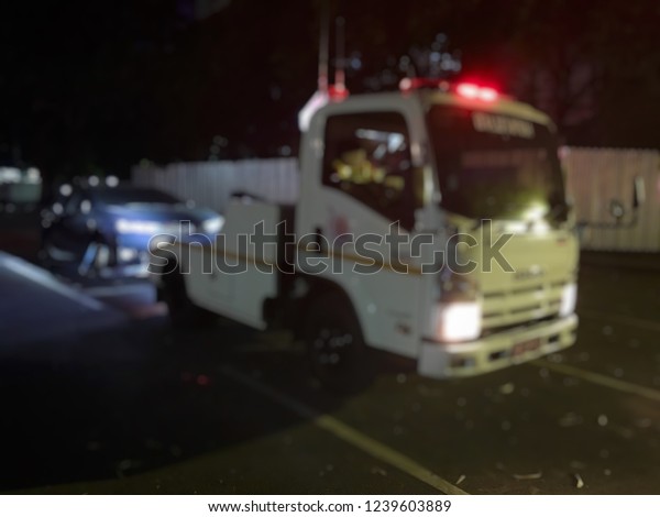 Blurred of police department tow truck are\
towing black vehicle are broken on the road to prevent the danger\
of accident duplicate and deliver to the\
garage