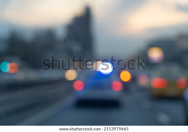 Blurred Police\
emergency lights flash at night. Blurred lights of a police car on\
a busy city street. Emergency response police patrol vehicle\
speeding to scene of crime at\
night.