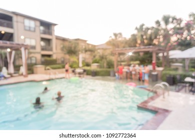 Blurred Pool And BBQ Party At Apartment Complex In America. Family Oriented Event With Kids, Parents Swimming And Residential Hanging Out