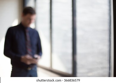 Blurred Portrait Of Young Businessman Use Telephone For Communication In Office Environment.