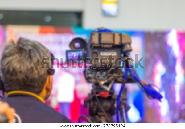 blurred professional cameraman - control a\
camera and covering on an event with a video \
