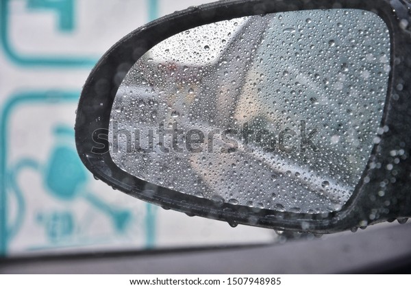 Blurred rain drop on the car glass background,\
water drops at the car window driver side. Autumn concept with rain\
drops on the car window. drop of water on glass. Wet car windshield\
in rainy autumn
