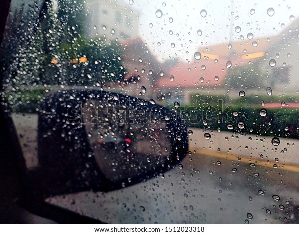 Blurred rain drop on the car\
glass background, water drops at the car window driver side -\
Image