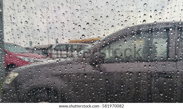 Blurred rain drop\
on the car glass background, water drops at the car window driver\
side, vintage color\
\
