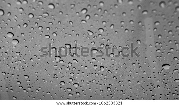 Blurred rain drop or water droplets on glass of car in\
raining 