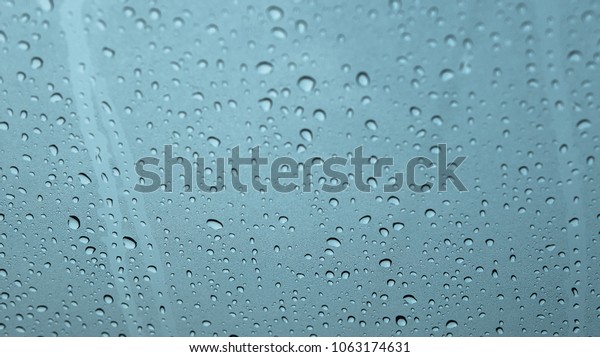 Blurred rain drop or water droplets on glass of car in\
raining 