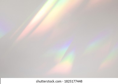 Blurred rainbow light refraction texture overlay effect for photo and mockups. Organic drop diagonal holographic flare on a white wall. Shadows for natural light effects - Shutterstock ID 1825177448