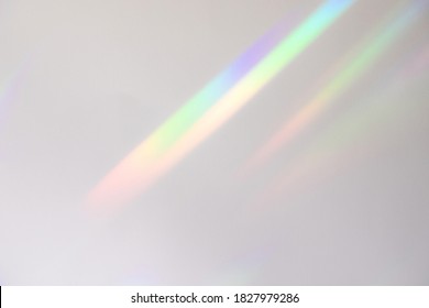 Blurred rainbow light refraction texture overlay effect for photo and mockups. Organic drop diagonal holographic flare on a white wall. Shadows for natural light effects - Shutterstock ID 1827979286