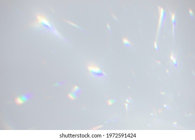 Blurred rainbow light refraction texture overlay effect for photo and mockups. Organic drop diagonal holographic flare on a white wall. Shadows for natural light effects - Shutterstock ID 1972591424