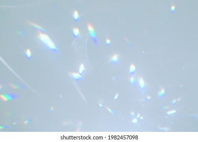 Blurred Rainbow Light Refraction Texture Overlay Effect For Photo And Mockups. Organic Drop Diagonal Holographic Flare On A White Wall. Shadows For Natural Light Effects