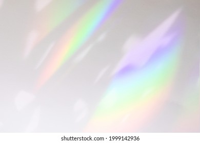 Blurred rainbow light refraction texture overlay effect for photo and mockups. Organic drop diagonal holographic flare on a white wall. Shadows for natural light effects - Shutterstock ID 1999142936