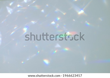 Blurred rainbow light refraction texture overlay effect for photo and mockups. Organic drop diagonal holographic flare on a white wall. Shadows for natural light effects