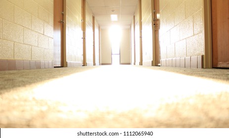 Blurred Ray Of Light Shining Down Carpet Of College Dorm Hallway.