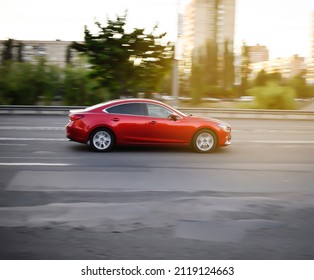 Blurred red sport car fast driving, automobile moving on open empty city street road, highway. Motion blur effect, selective focus - Shutterstock ID 2119124663