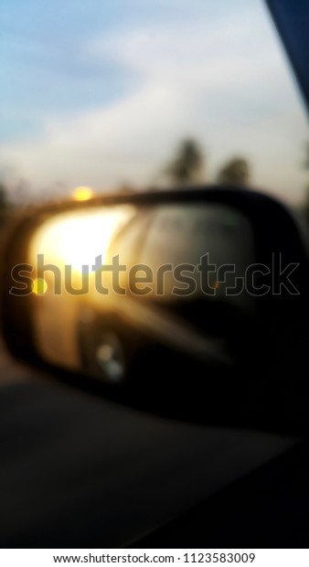 Blurred Reflection of the sun light from the\
car\'s side mirrors