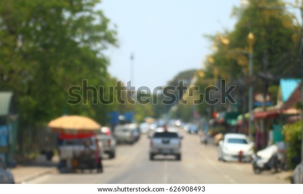 blurred
road and car background abstract of Long road way in city with car
and two side of building and home market
street