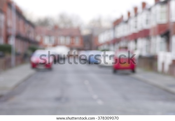Blurred\
road with cars and houses in Manchester,\
England.