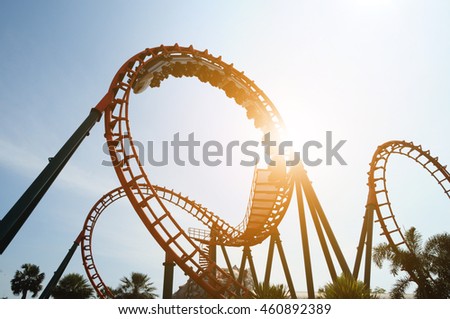 blurred Roller coaster ride in amusement park at evening, low key