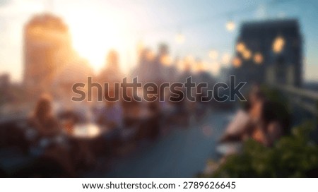 A blurred rooftop bar scene features people sitting at tables during sunset with a city skyline background and hanging string lights in a soft focus photography style.