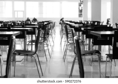 Blurred rows of wooden tables and plastic chairs in the restaurant, black and white - Shutterstock ID 590272376