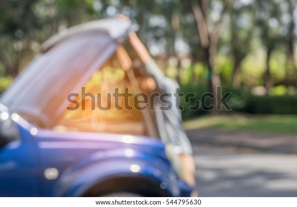 Blurred of sad man\
looking at his broken\
car
