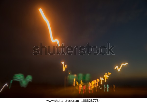 Blurred scene of driving at\
night with speed or drunk driver, motion line of electricity light\
on road and led billboard. Abstract background and drive safety\
concept.