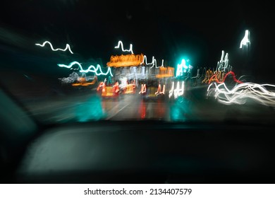 Blurred and shaky traffic and car lights captured by long exposure photography on a night road trip in England