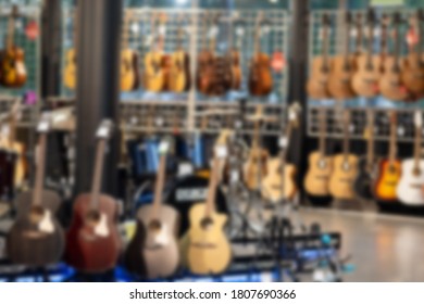 Blurred shop of classical guitars, interior made of guitars