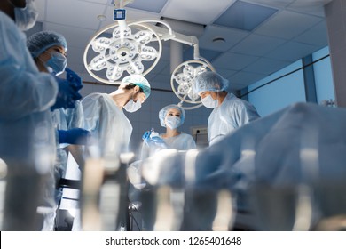 Blurred Shot Of Group Of Professional Surgeons At Work In Operating Room. Emergency Case, Surgery, Medical Technology, Health Care Cancer And Disease Treatment Concept