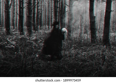 blurred silhouette of a terrible witch with a skull in her hands performing a mystical occult satanic ritual. Black and white with 3D glitch virtual reality effect - Shutterstock ID 1899973459