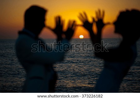 Blurred silhouettes on the background of the sea. Focus on the water