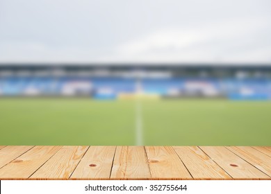 Blurred Soccer Stadium In Sunny Day Backgrounds With Old Vintage Wooden Desk Tabletop,put And Show Your Products On Display Or Wallpaper