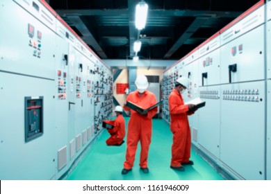 Blurred and Soft focus of Engineer checking and monitoring the electrical system in Electrical switch gear at Low Voltage motor control center cabinet room,Electrical selector switch,button switch.